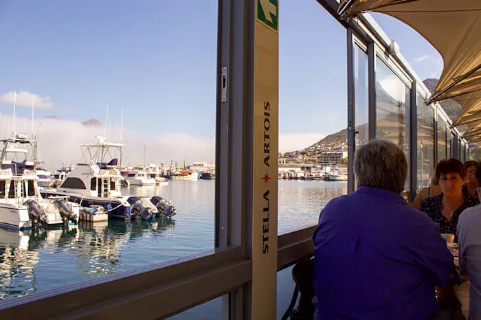 Guests at the glass edge of the deck looking over moored boats