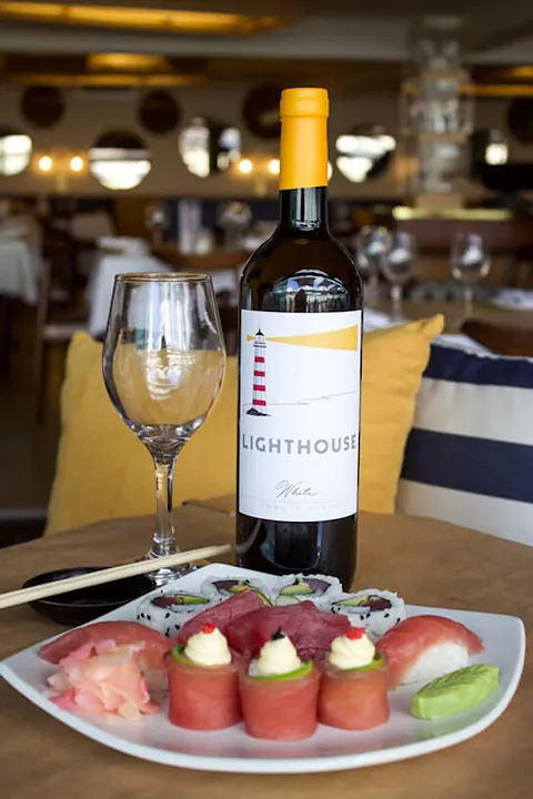 A bottle of The Lighthouse wine on a table inside