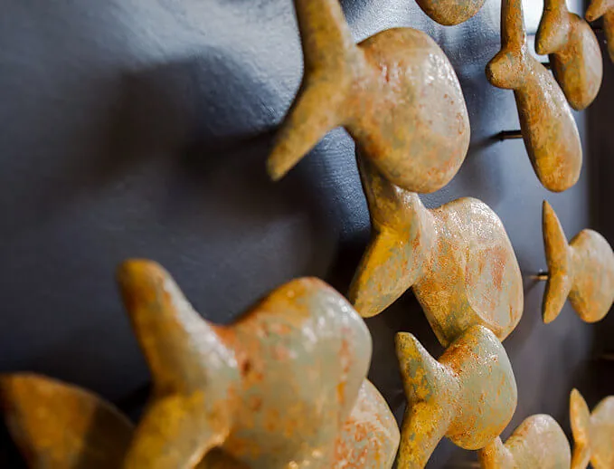Close-up of the bronze fish sculptures on the dark wall